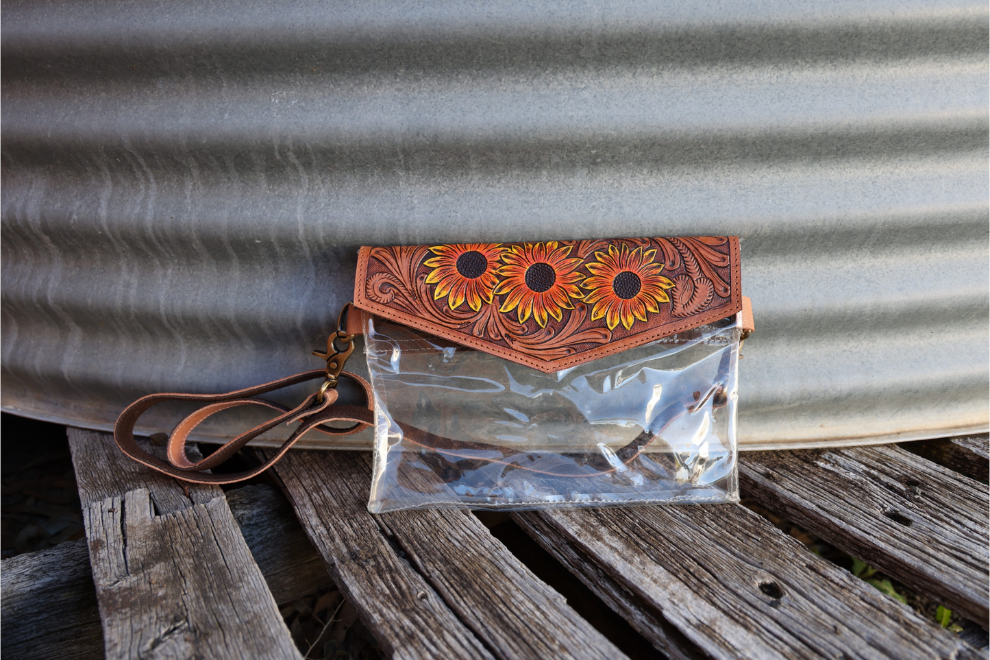 Hand tooled leather clutch with clear pvc body.
Sunflower floral details hand carved & painted.