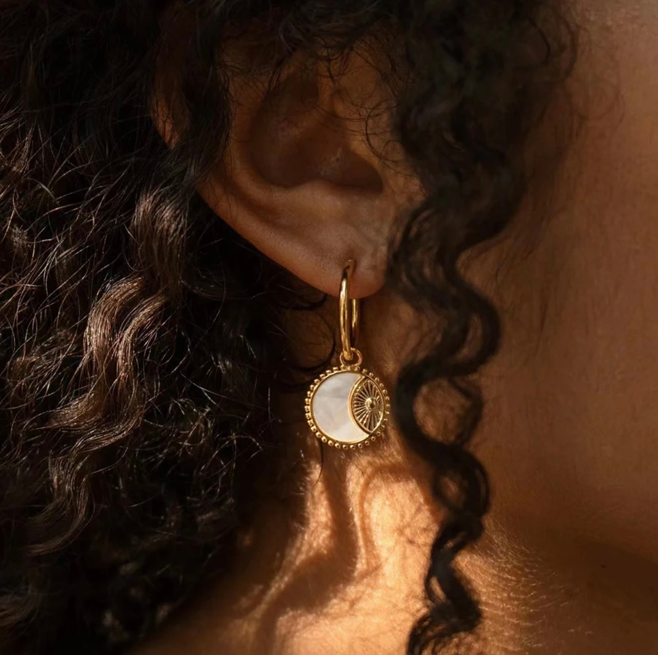 Sparkling Natural White Fritillaria Stone Hoop Earrings. 
Each earring holds a natural fritillaria stone set & the evil eye , the eye acts as a shield, reflecting the ill-will back onto the onlooker. Featuring 14k gold-plated hoops, pendent is removable from hoops & hoops can be warn alone or with the pendent.