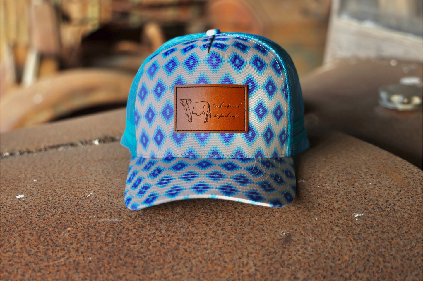 Cream cap, sky blue + purple aztec pattern on & under brim.

Leather patch on front panel, “Fuck around and find out” Mickey bull.
Blue mesh & snapback.

