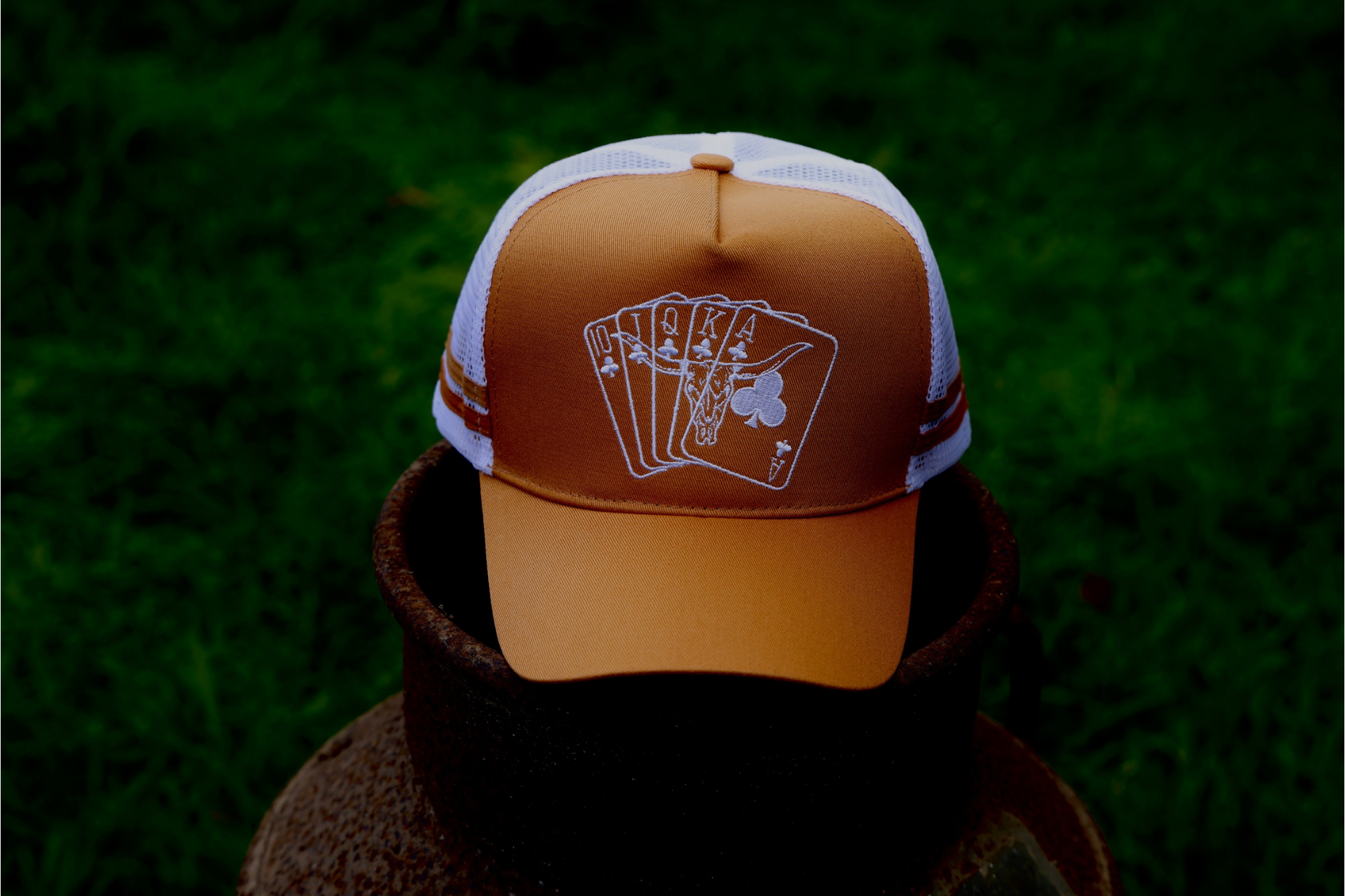 Tan mustard coloured Trucker Cap with with mesh & SnapBack.
White embroidered cards & Bull skull in the front panel. 