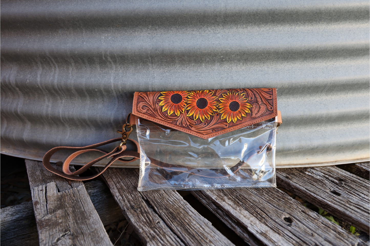 Hand tooled leather clutch with clear pvc body.
Sunflower floral details hand carved & painted. 